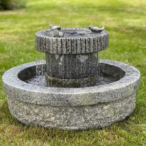 Solid granite water feature with a circular design, featuring a raised central column topped with carved stone birds